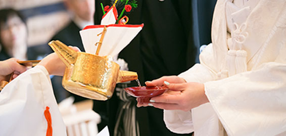 花嫁の持つ盃に巫女がお神酒を注ぐ